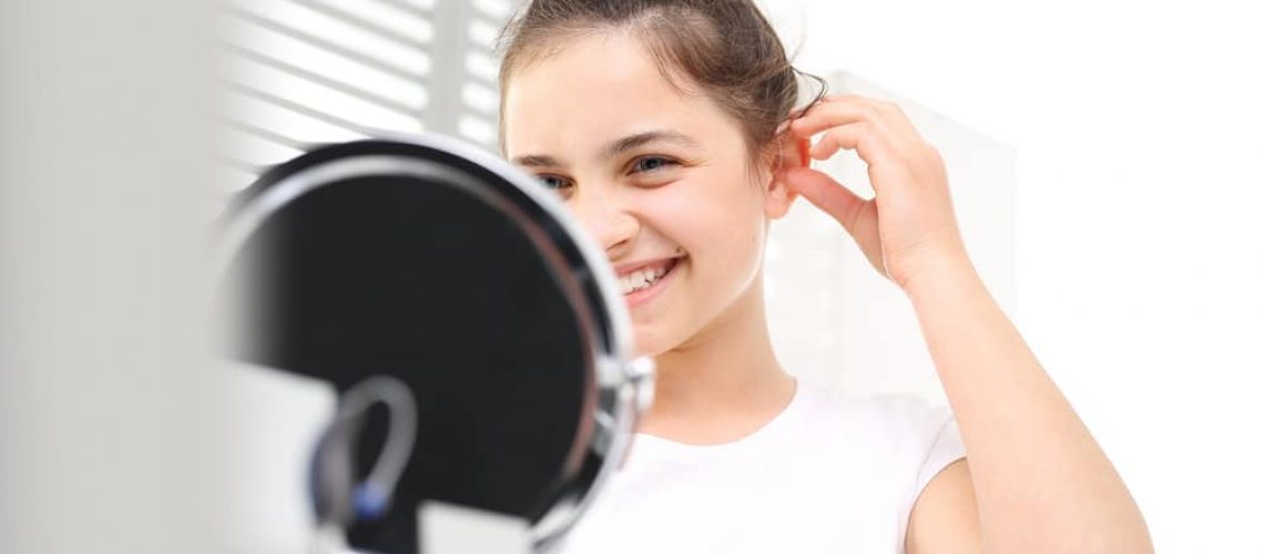 The,Hearing,Aid,For,A,Child.,Cheerful,Girl,Assumes,Hearing