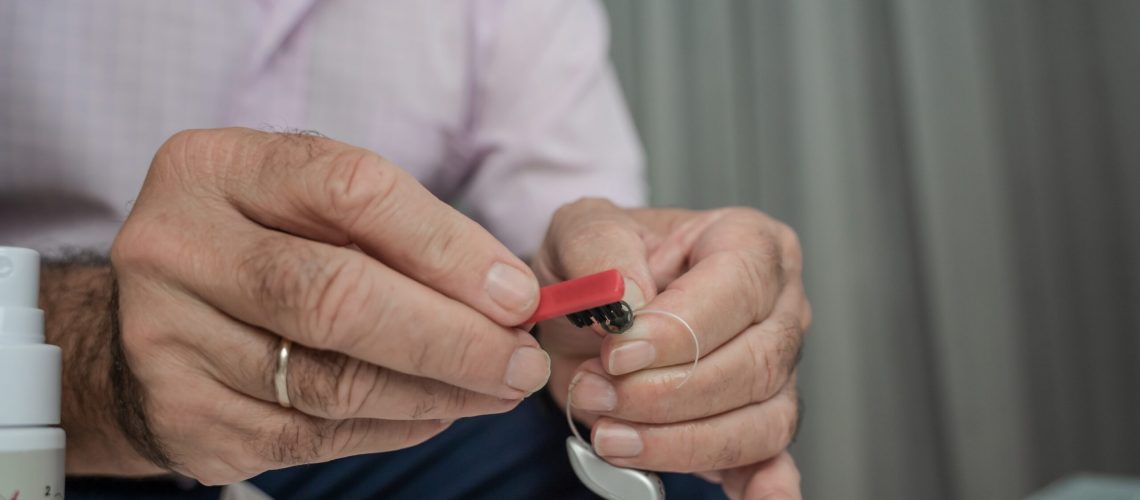 Grandfather,Cleaning,His,Hearing,Aids,So,He,Can,Listen.